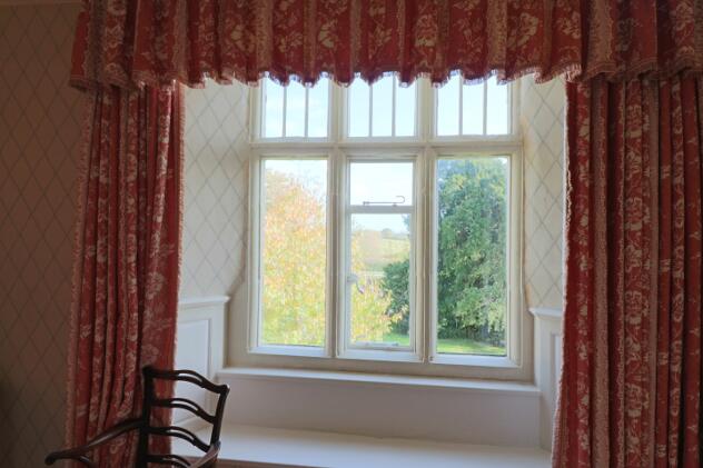 Feature stone-mullioned window and window seat in Yate room with countryside views